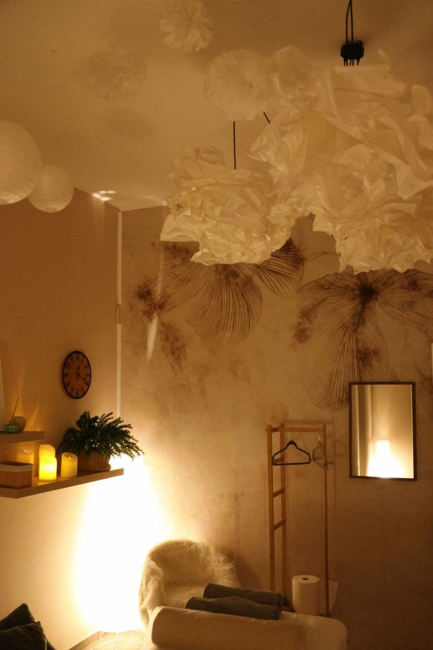 Gabinet z papierowymi lampionami pod sufitem, kwiatową ścianą i wieszakiem na ubrania