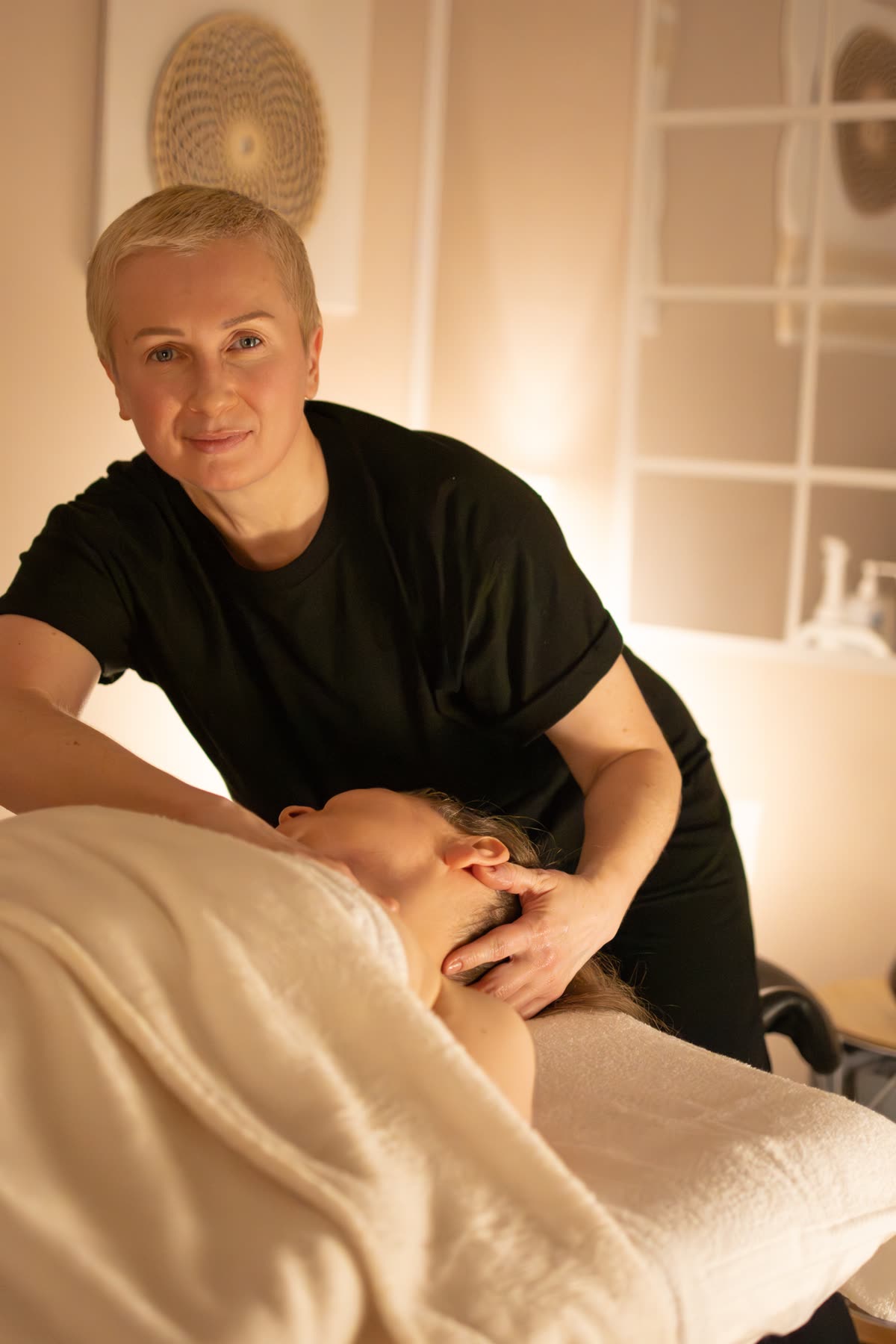 Terapeutka pracuje nad karkiem klientki podczas masażu zdrowotnego w studiu Massage 4 You w Poznaniu